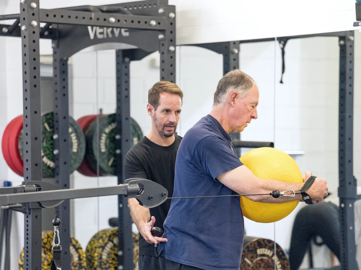 A member being coached through a scaled movement